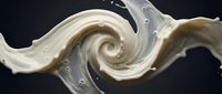 Creamy white liquid swirls in dynamic spiral motion against dark background, capturing fluid movement and texture for abstract design projects.