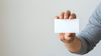 Man holding blank white business card in hand against neutral background, suitable for corporate branding, contact information display, and professional marketing materials.