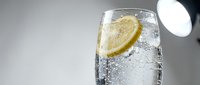 Refreshing sparkling water with fresh lemon slice and ice cubes in a clear glass, perfect for beverage, food and drink, wellness and hydration design projects.