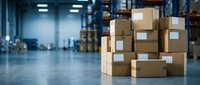 Stacked cardboard boxes in modern warehouse with industrial shelving and fluorescent lighting, logistics and shipping storage facility.