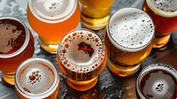 Variety of craft beer samples in tasting glasses showing different colors from light lager to dark ale, perfect for brewery menu, bar promotion or beer festival advertising.