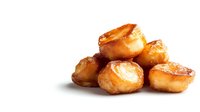 Golden crispy roast potatoes with caramelized edges isolated on white background, perfect for food blogs and restaurant menu designs.