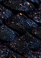 Water droplets on dark diagonal surface with glowing orange bokeh lights creating dramatic contrast and mysterious atmosphere. Suitable for abstract backgrounds.