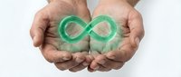 Hands holding glowing green infinity symbol representing endless possibilities, sustainability, and circular economy concepts for business presentations.