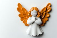Cute praying angel figurine with orange wings and red hair, isolated on white background, perfect for holiday and spiritual design projects.