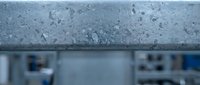 Raindrops on glass window with blurred urban cityscape background creating atmospheric weather mood for interior design and seasonal concepts.