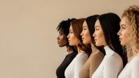 Diverse group of five young women in profile view wearing neutral turtleneck sweaters representing multicultural beauty and unity for inclusive campaigns.