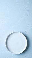 Empty white ceramic plate on light blue textured surface, overhead view for food styling, product photography, and culinary design projects.