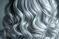 Luxurious platinum blonde wavy hair texture closeup showing professional styling and highlights in monochromatic tones, suitable for beauty and fashion industry use.