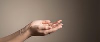 Open cupped hands gesture showing palm up in receiving position against soft gradient background for presentation and offering concepts.