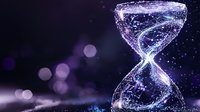 Glowing digital hourglass made of connected dots and lines against dark background with bokeh lights, representing time, technology and digital transformation.