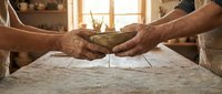 Hands sharing wooden bowl of flour in rustic kitchen, symbolizing community cooking, traditional baking and culinary collaboration in warm homestyle setting.