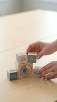 Hands arranging wooden wellness blocks with mindfulness symbols on natural wood surface for meditation and mental health concepts.