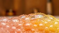 Close-up macro shot of fresh citrus fruit skin with water droplets, showing natural texture and vibrant orange colors for food photography and healthy lifestyle.
