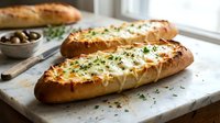 Freshly baked garlic bread with melted cheese and herbs on rustic wooden cutting board, perfect for Italian cuisine and comfort food recipes.