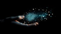 Hand holding glowing blue particle cloud against black background, creating magical effect of digital transformation and futuristic technology concept.