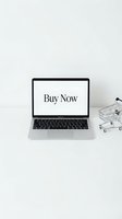 Laptop with Buy Now text on screen next to a mini shopping cart on white background, symbolizing online shopping and e-commerce.