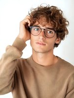 Young Caucasian man with curly brown hair wearing eyeglasses and beige sweater scratching head in confusion isolated on white background for design use.