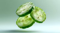 Fresh cucumber slices floating in air against green background, showing crisp texture and juicy interior. Minimalist food photography for healthy eating concepts.