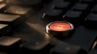 Red cancel button on black keyboard with dramatic lighting and shallow depth of field for business and technology concepts.