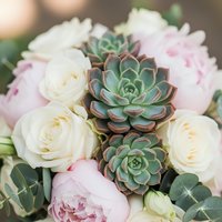 Elegant wedding bouquet with soft pink peonies, white roses and green succulents for bridal arrangements and romantic celebrations.