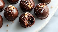 Gourmet chocolate truffles with nuts and cocoa powder coating on white marble surface. Luxury confectionery desserts for bakery menu and sweet treats advertising.