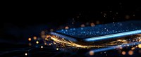 Abstract golden and blue light waves with glowing particles and bokeh effect on dark background, modern luxury design element for festive backdrop.