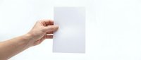 Hand holding blank white paper sheet against clean background for mockup and template design projects.