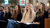 Young diverse congregation members laughing joyfully during church service, sitting in wooden pews with hymnals, expressing genuine happiness and spiritual connection.
