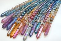 Colorful crystal quartz points and beads arranged in rows showing rainbow spectrum of natural minerals, healing stones on white background for jewelry making.