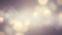 Abstract blurred bokeh lights background in soft purple and golden tones creating dreamy atmospheric effect for elegant design projects.