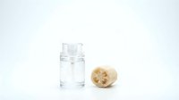 Glass jar with clear water and natural loofah sponge on white background for spa, skincare and eco-friendly bathroom products.