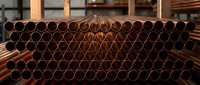 Industrial copper pipes stacked in warehouse for plumbing, construction and manufacturing applications in organized rows ready for distribution.