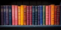 Row of vintage hardcover books in various colors arranged on dark wooden shelf, spines showing classic literature collection against black background.