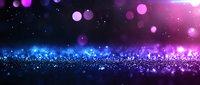 Magical glowing particles with purple and blue bokeh lights on dark background create dreamy atmosphere for festive designs and holiday backgrounds.