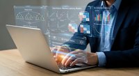 Professional businessman analyzing financial data and charts on laptop with holographic business intelligence dashboard displaying graphs and analytics.