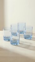 Set of five empty blue tinted drinking glasses arranged on wooden table against neutral beige background for kitchen and dining room decor.