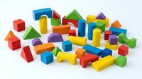 Colorful wooden building blocks set with various geometric shapes including cubes, cylinders, triangles and rectangles isolated on white background for educational play.