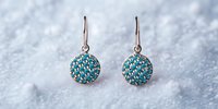 Elegant round earrings with turquoise crystals on silver hooks against snowy white background, showcasing luxury jewelry accessories for special occasions.