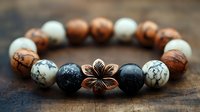Handcrafted bracelet with natural stone beads and copper flower charm on wooden surface, featuring white howlite, black lava rock, and wooden elements in bohemian style.