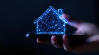 Glowing blue holographic house floating above hand in dark background, digital real estate concept visualization for smart home technology and property innovation.