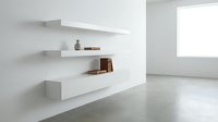 Modern minimalist interior with white floating shelves displaying ceramic vases and books against clean wall in bright contemporary living space.