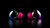 Wireless earbuds with colorful LED lighting effects on black background. Modern pink and black headphones with rainbow glow reflect on dark surface.