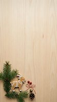 Gingerbread goat cookie with evergreen branches, pinecone, and red berries arranged on light wood surface for holiday baking and seasonal decoration projects.