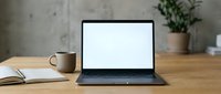 Modern laptop with blank white screen on wooden desk workspace with coffee cup and plant for remote work and productivity mockup.