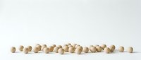 Natural wooden beads scattered on white surface creating minimalist craft supply arrangement for jewelry making and DIY projects.