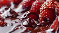 Fresh ripe strawberries covered in dark melted chocolate sauce creating luxurious dessert composition with rich textures and dramatic lighting.