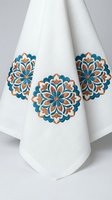 White kitchen towel with colorful mandala embroidery featuring teal and orange floral patterns for home decor and cooking accessories.