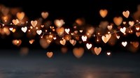 Romantic heart-shaped bokeh lights floating over dark wooden surface creating warm golden glow for Valentine's Day celebration and love themed designs.