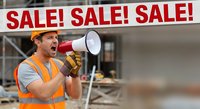 Construction worker in safety vest shouting through megaphone announcing sale promotion at building site for marketing and advertising campaigns.